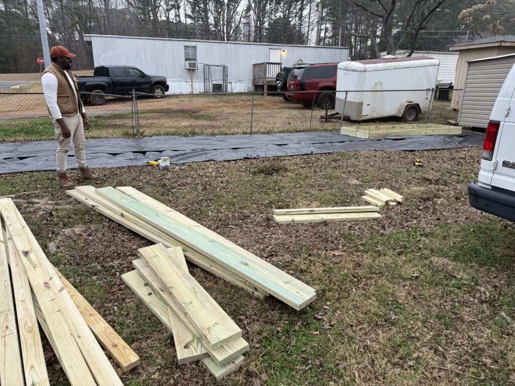 Man standing near lumber in backyard construction
