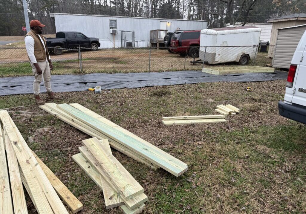 Man standing near lumber in backyard construction